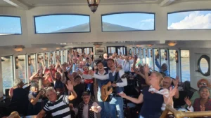 Bedrijfsuitje groepsfoto boot juichende mensen gezelligheid en plezier bij pubquiz